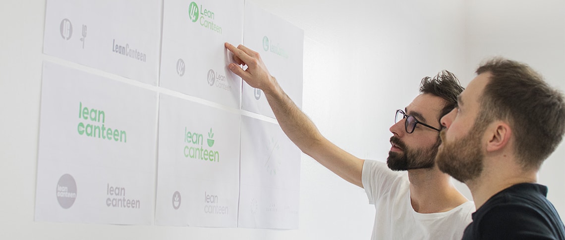 Two graphic designers reviewing logo design and brand identity concepts