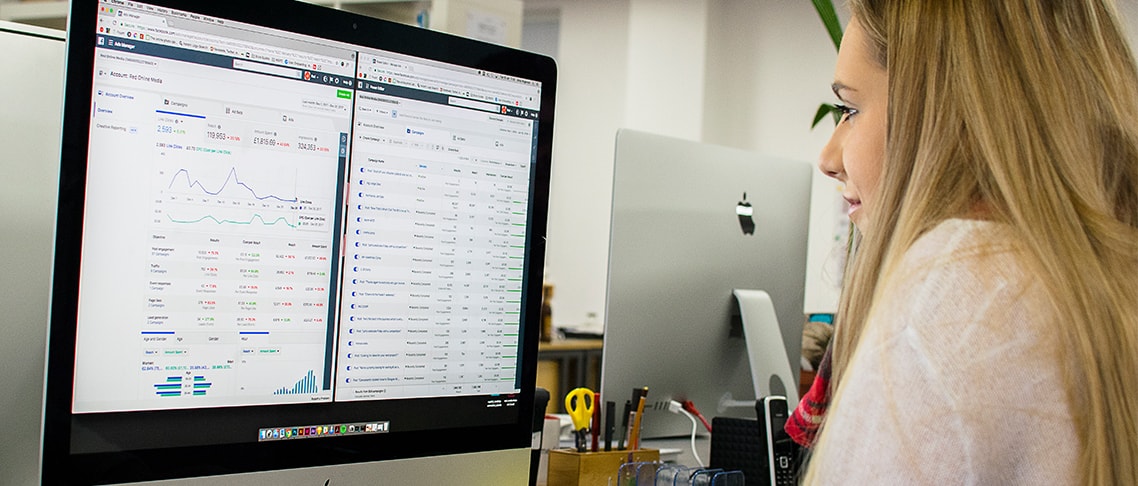 Whitespacepw social media marketing assistant working at a computer and reviewing Facebook analytics.