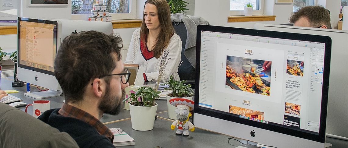 Whitespacepw designer working at a computer designing a website for 'Bab's restaurant.